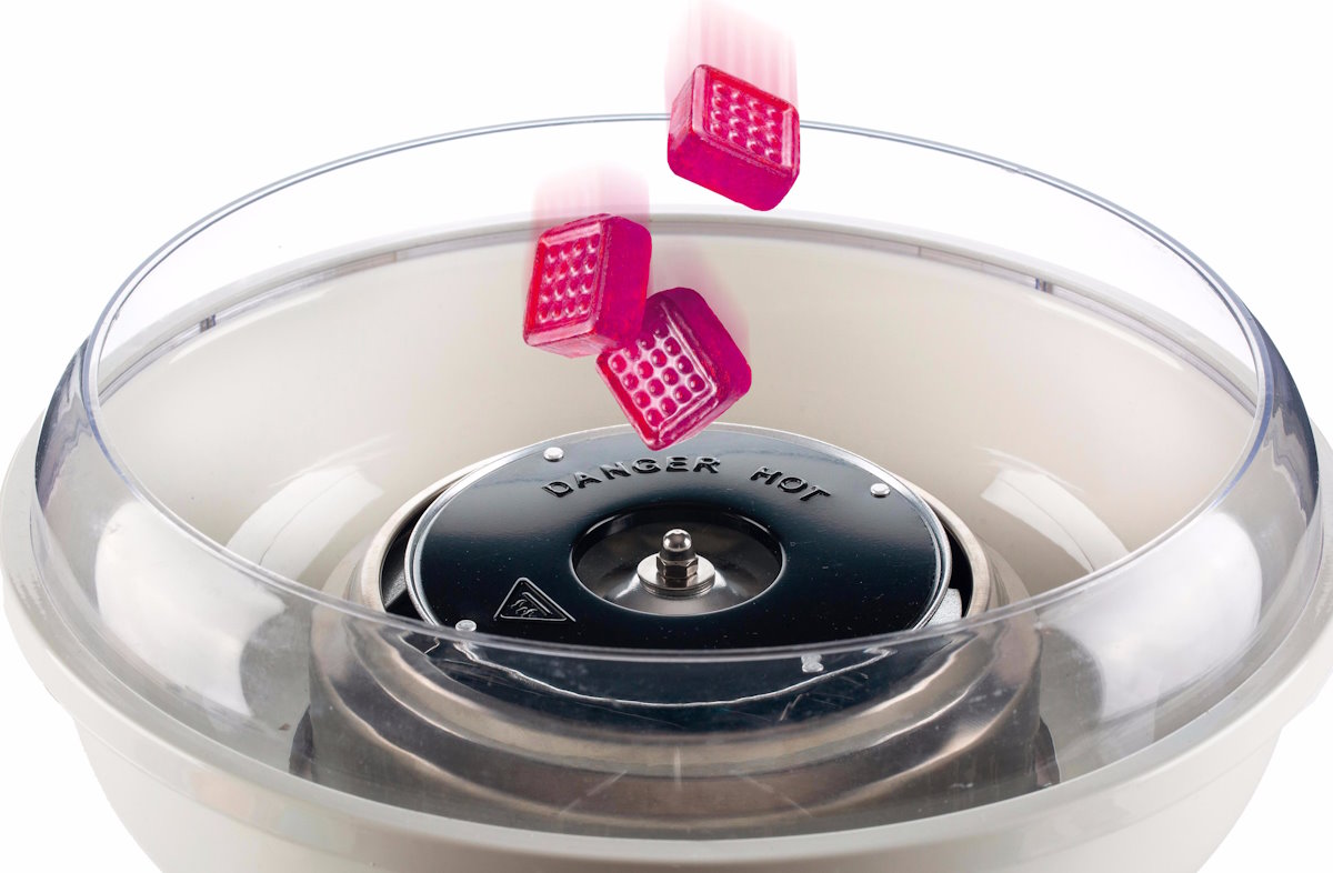 ARIETE Zuckerwattemaschine, Detailaufnahme des Einfüllens von Zucker in den Heizkörper. ARIETE Zuckerwattemaschine, Detailaufnahme des Einfüllens von Zucker in den Heizkörper.