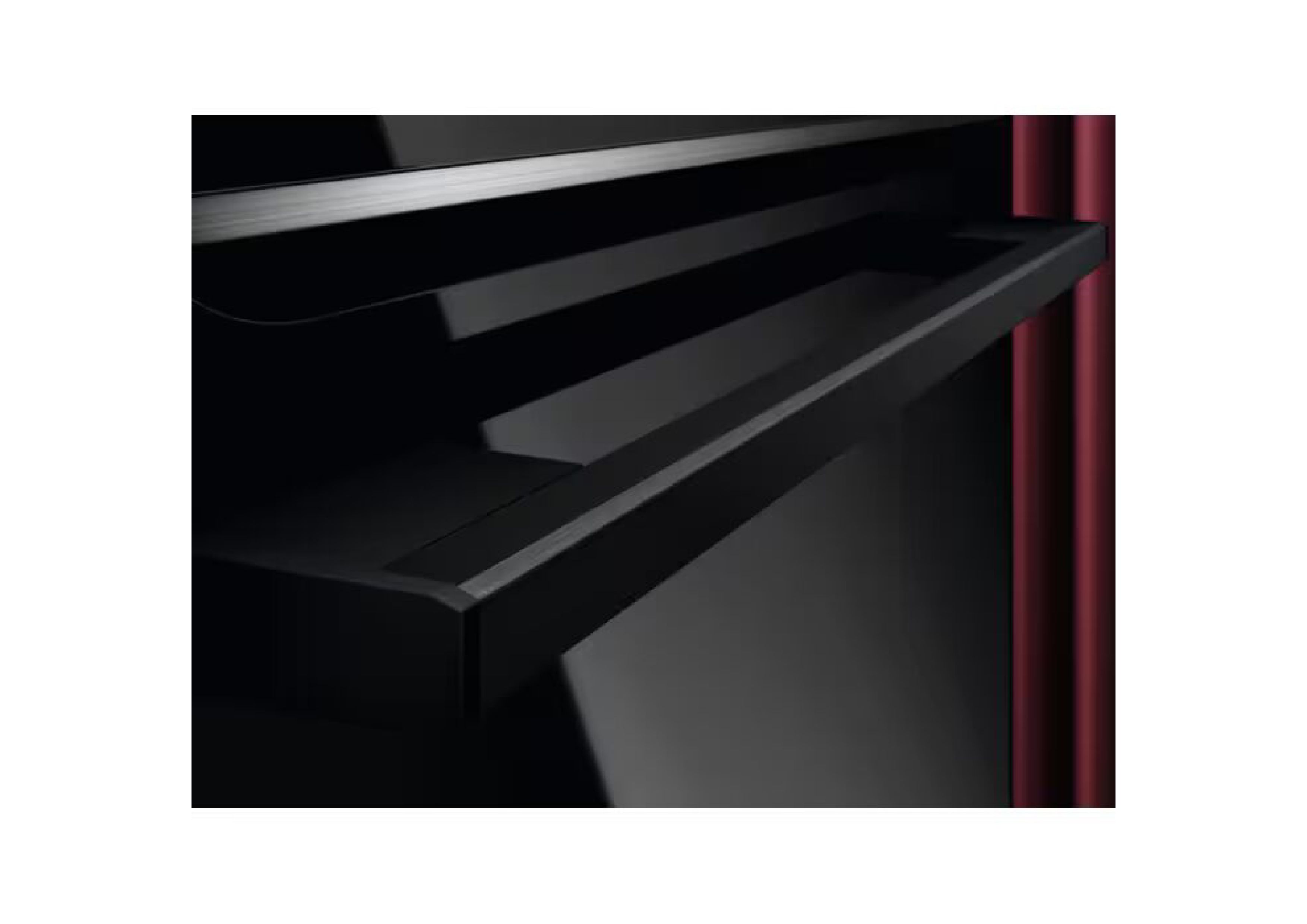 Close-up of the black oven door handle against a red background,