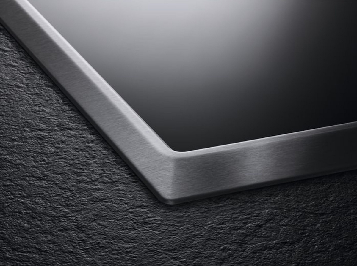 Detailaufnahme des OptiFit Edelstahlrahmens an der Ecke des Kochfeldes.