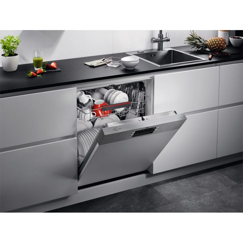Geöffneter Geschirrspüler mit ausgezogenen Körben und Besteckkorb, Innenraum aus Edelstahl.