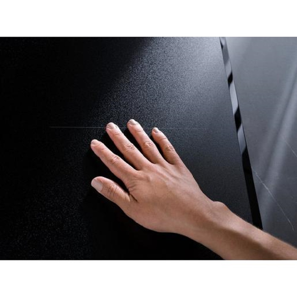 Eine Hand berührt die matte, strukturierte SaphirMatt Glasoberfläche des AEG Kochfeldes.