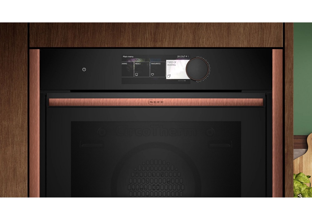 Nahaufnahme der schwarzen Glasbedienblende eines NEFF Backofens mit digitalem Display und seitlichen Kupferleisten.