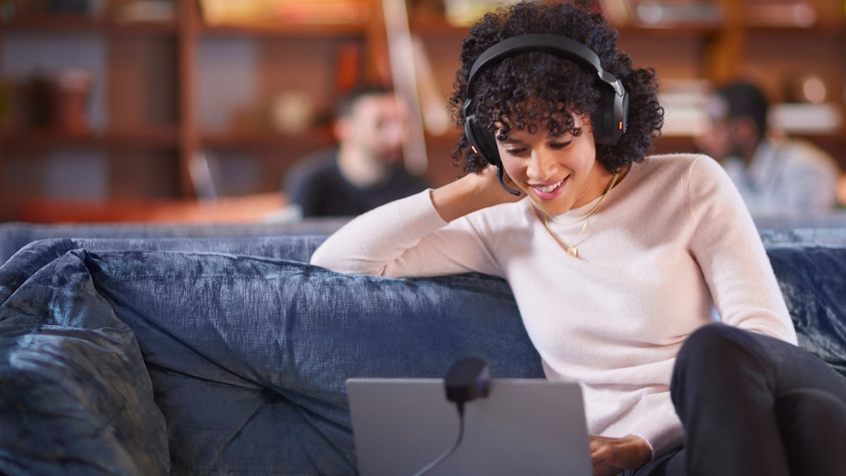 Person trägt das schwarze Over-Ear Headset in einer modernen Büroumgebung.