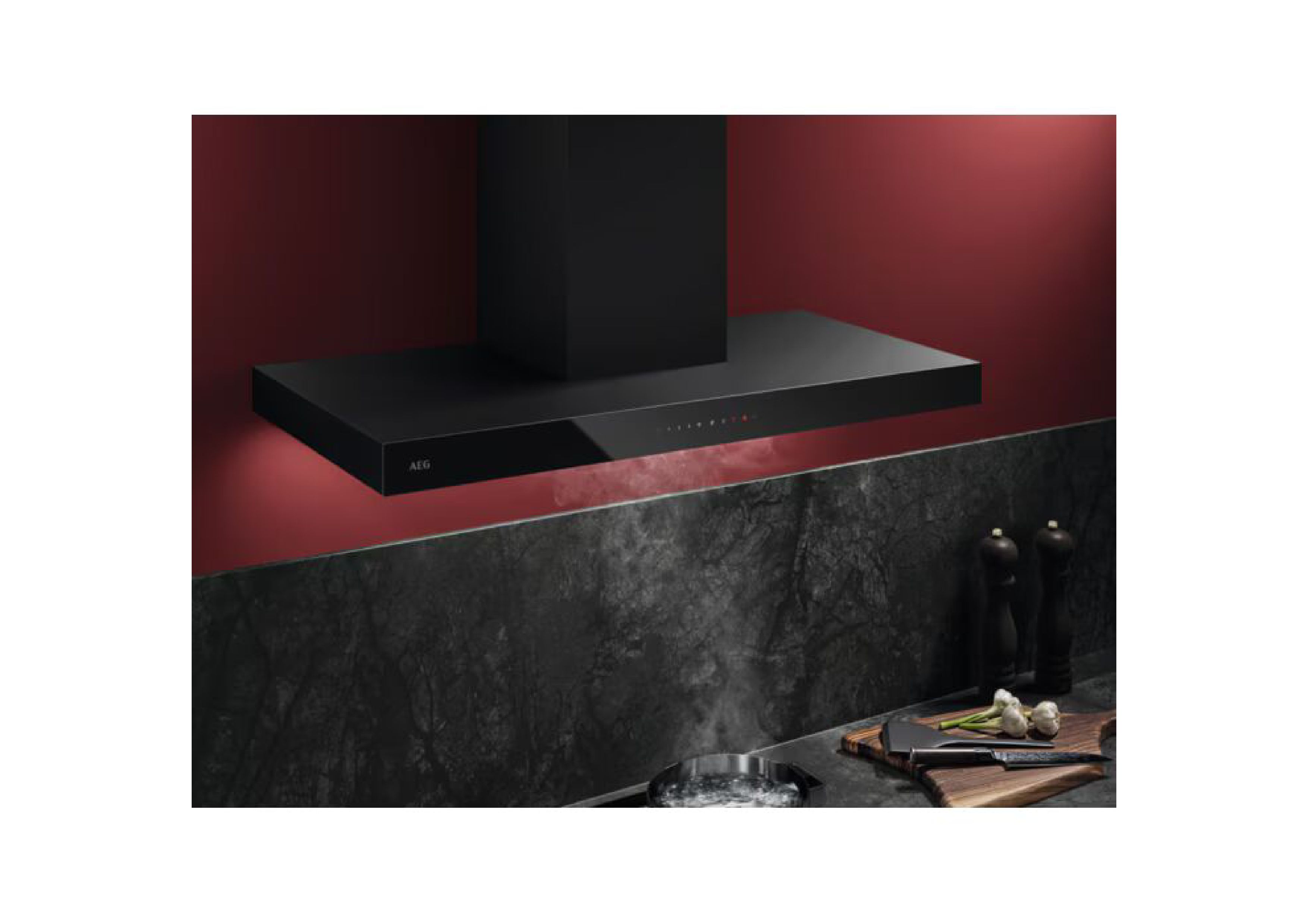 Lifestyle-Aufnahme einer schwarzen AEG Dunstabzugshaube in einer Küche über kochendem Wasser mit Dampf vor roter Wand.