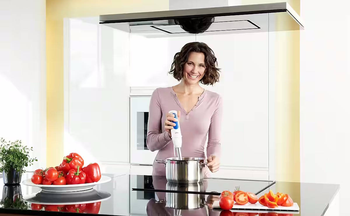 Hand blender used for pureeing a vegetable soup in a pot