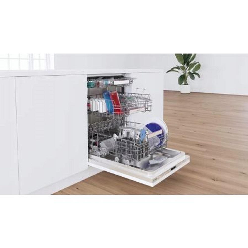 Fully loaded Bosch dishwasher integrated into a white kitchen island in a bright, modern room.