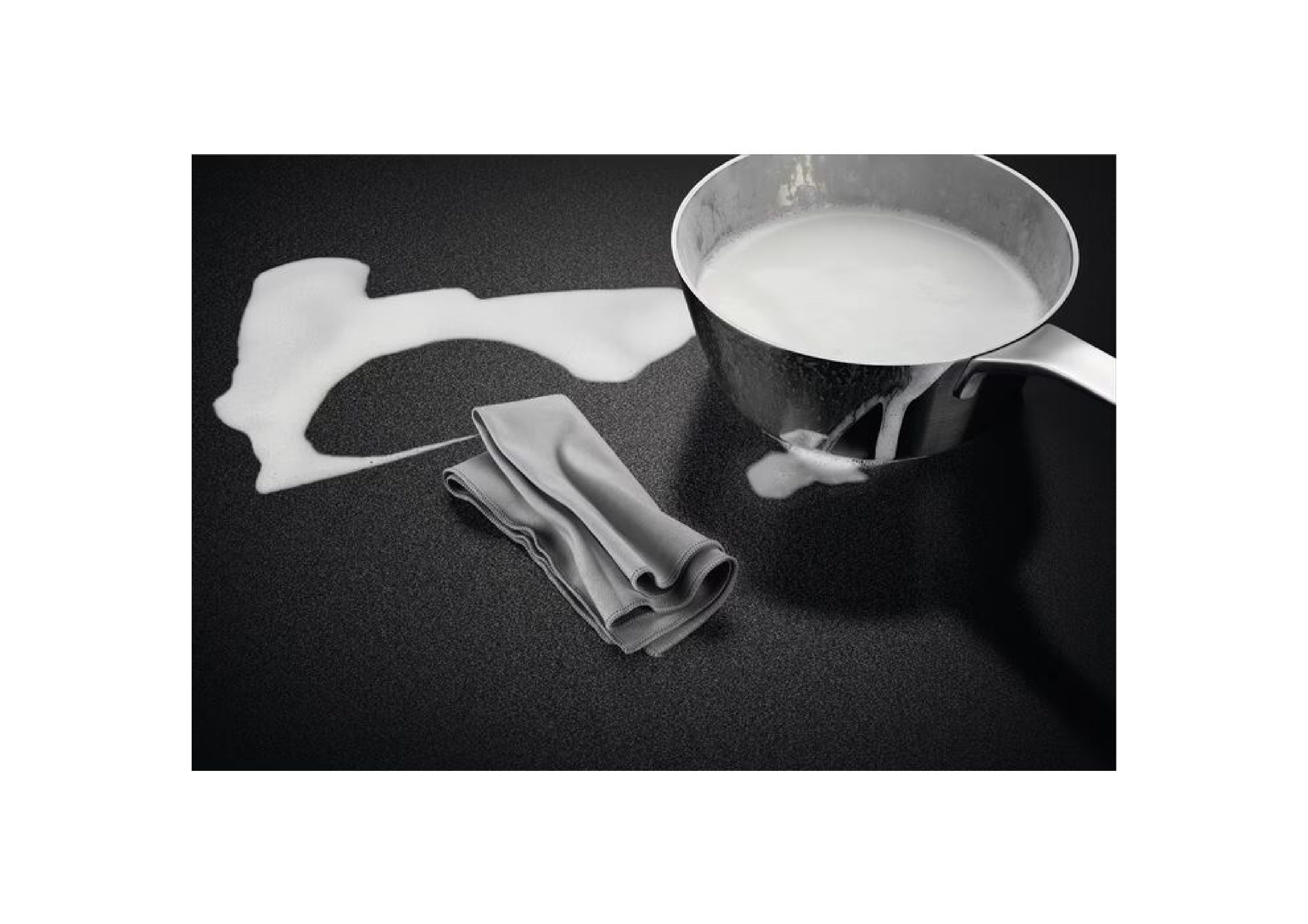 Detail view demonstrating easy cleaning of the AEG SaphirMatt hob with spilled liquid, pot, and cleaning cloth.