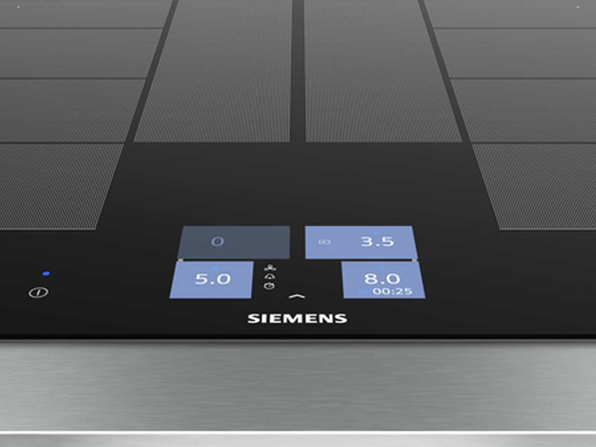 Nahaufnahme des Siemens Induktionskochfeldes mit leuchtend blauen Touch-Bedienfeldern und digitaler Anzeige für Kochstufen und Timer.