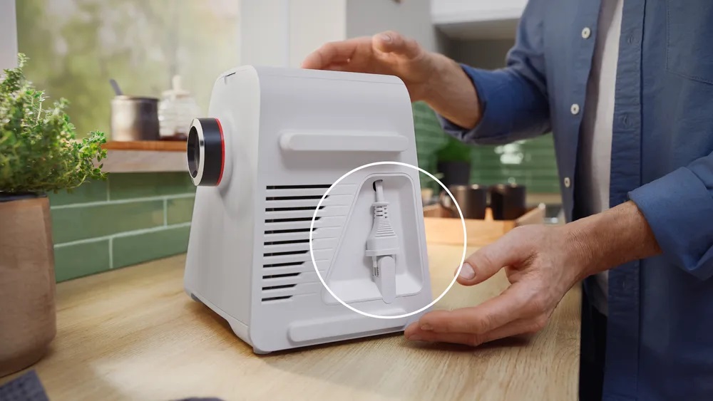 Bosch MFWS420W Kompakt-Fleischwolf – Kabelaufbewahrung Rückansicht des Bosch MFWS420W Kompakt-Fleischwolfs, mit einem Kreis, der die praktische integrierte Kabelaufbewahrung zeigt.