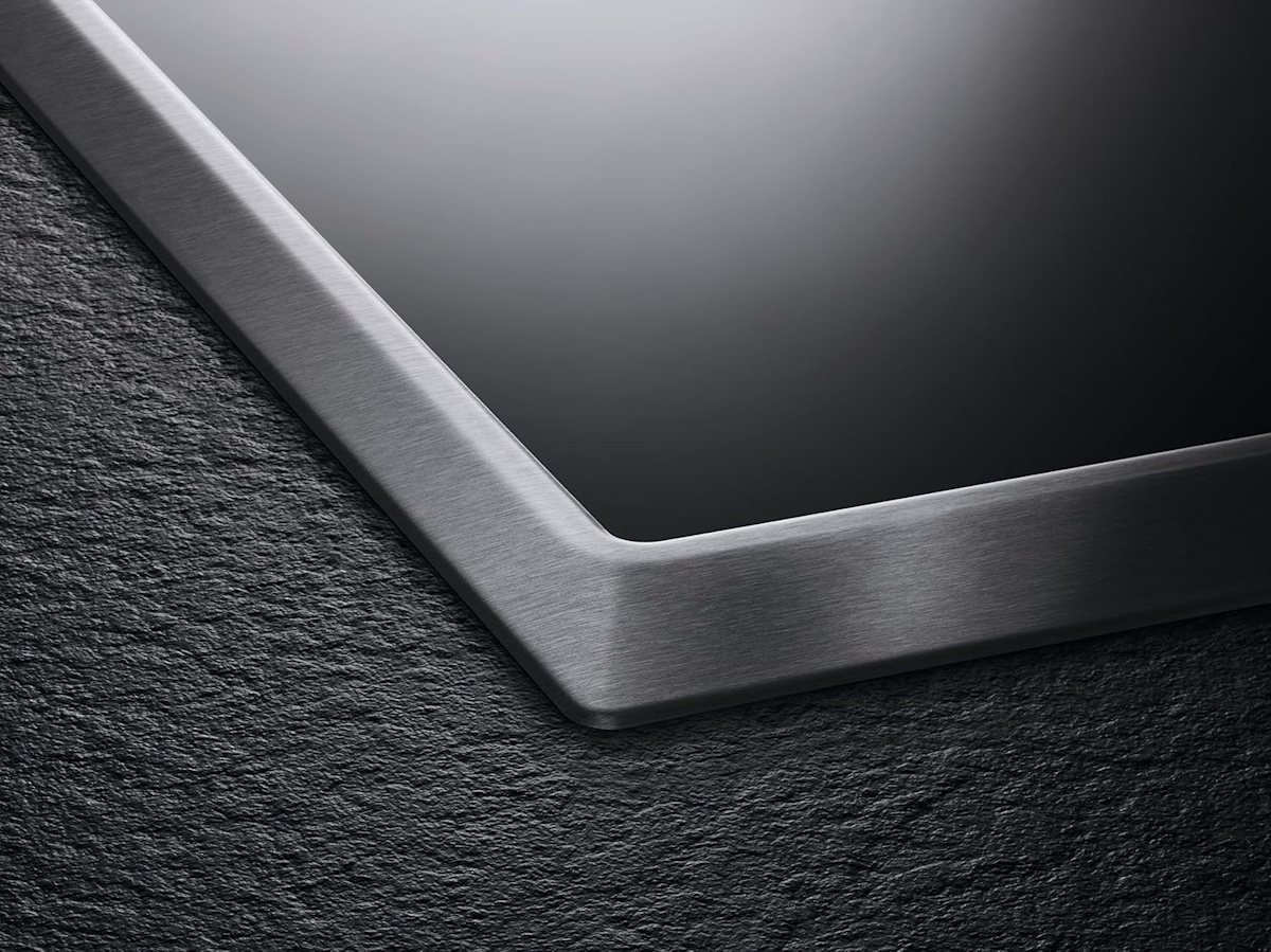Macro shot of the flat OptiFit stainless steel frame with subtle AEG logo branding.