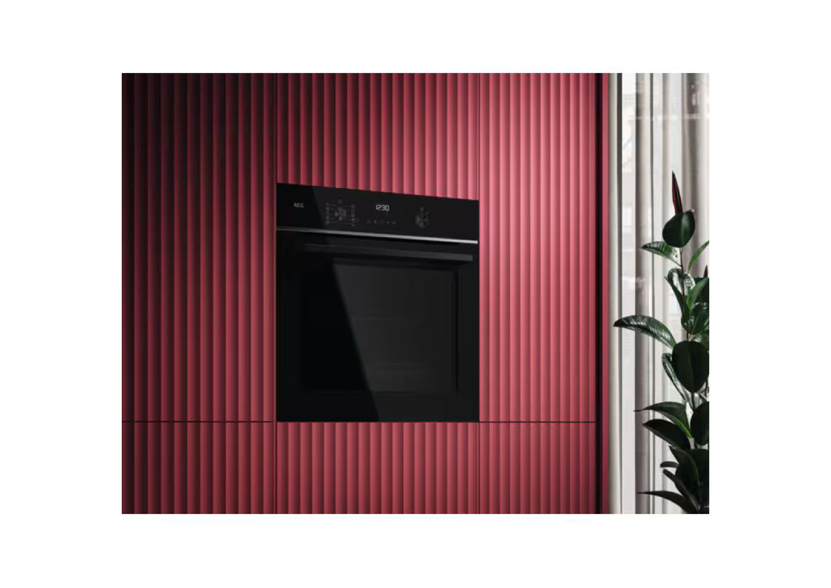 Black AEG built-in oven integrated into a red kitchen wall,
