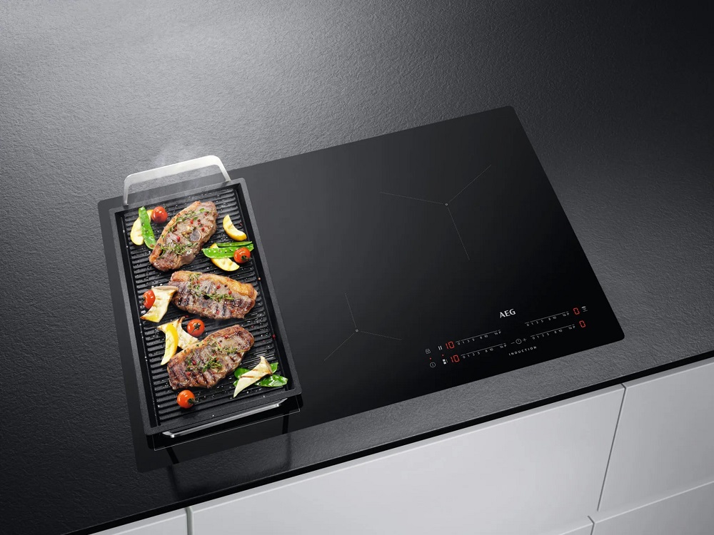 Szenebild: AEG IKE84445IB Induktionskochfeld mit großer Grillpfanne im Einsatz.