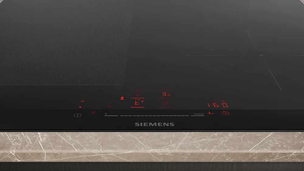 Siemens iQ700 EX675HEC1E Induktionskochfeld – Detail Bedienfeld Detailansicht des Touch-Bedienfelds vom Siemens EX675HEC1E Induktionskochfeld mit roten LED-Anzeigen und Siemens-Logo.