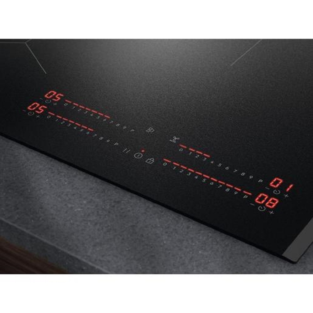 Perspektivische Nahaufnahme der leuchtenden Kochstufen-Anzeigen auf dem schwarzen Induktionskochfeld.