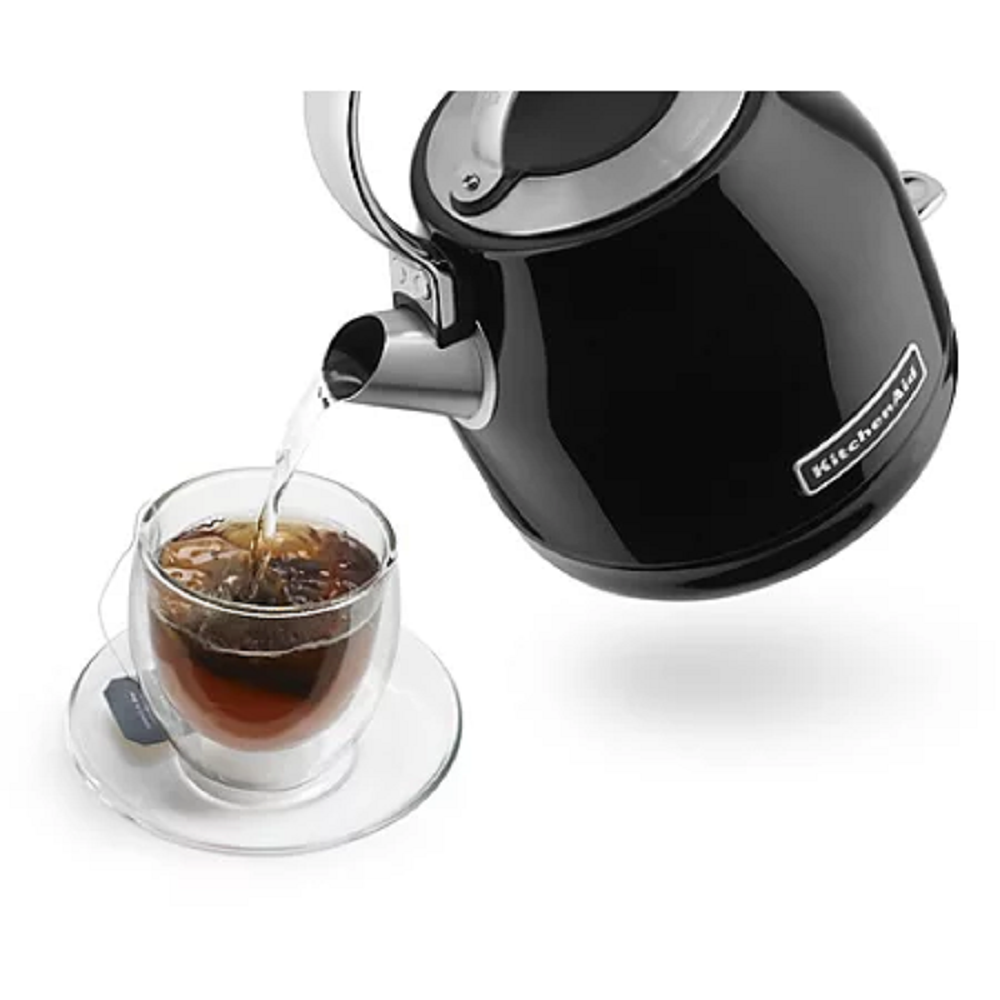 Wasser fließt aus dem KitchenAid Wasserkocher 5KEK1222EOB in eine Teetasse auf einem Tisch