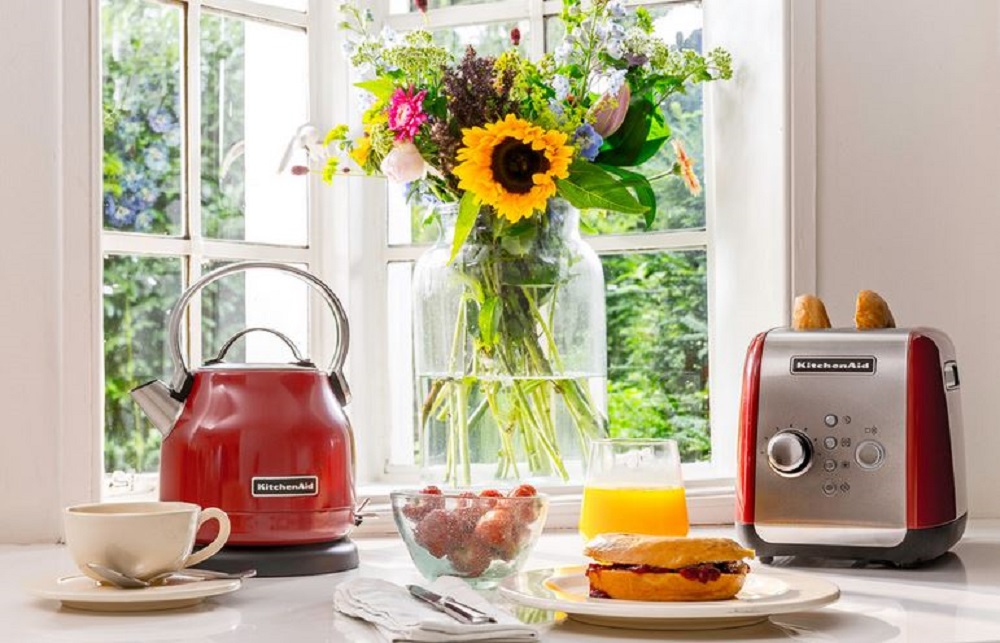 KitchenAid Wasserkocher 5KEK1222EER in Empire Red zusammen mit einem farblich passenden Toaster auf einer Küchenarbeitsfläche