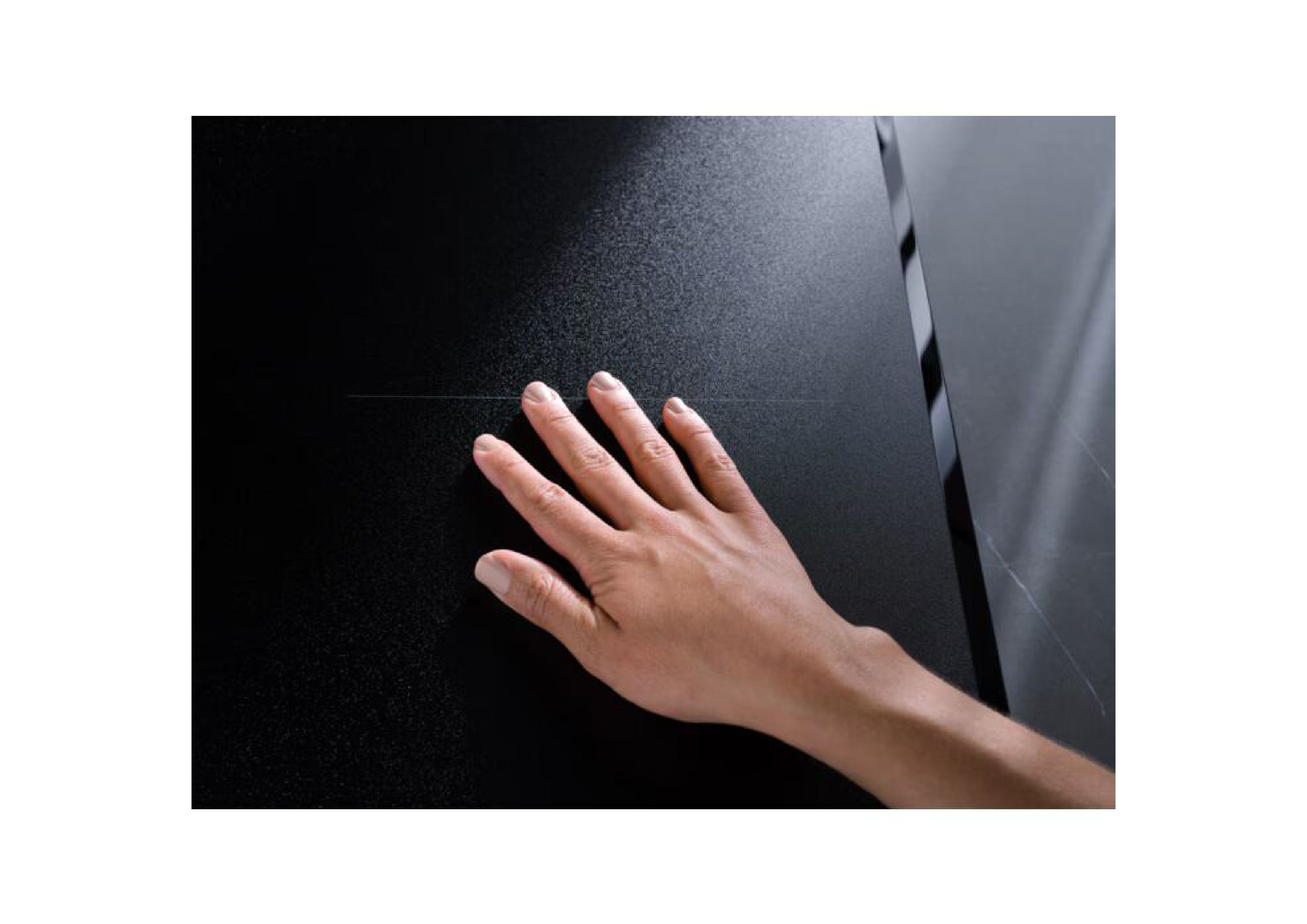 Detail view of a hand touching the textured, matte SaphirMatt surface of the AEG induction hob.