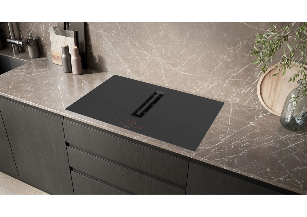 Installation of the frameless Siemens hob in a modern kitchen with a sophisticated natural stone countertop.