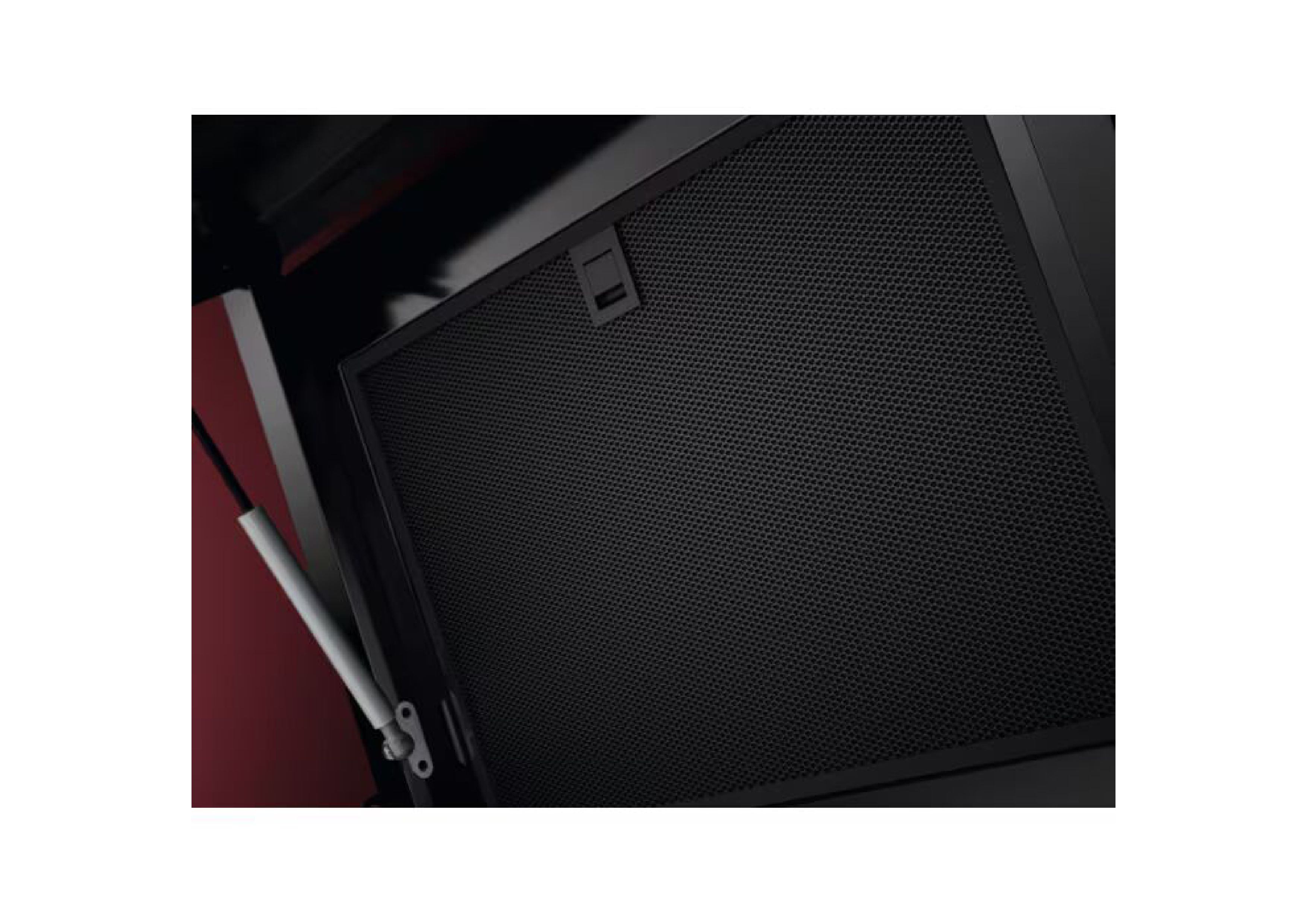 View under the opened front panel of the hood, held by a hydraulic damper, focusing on the black metal grease filter.