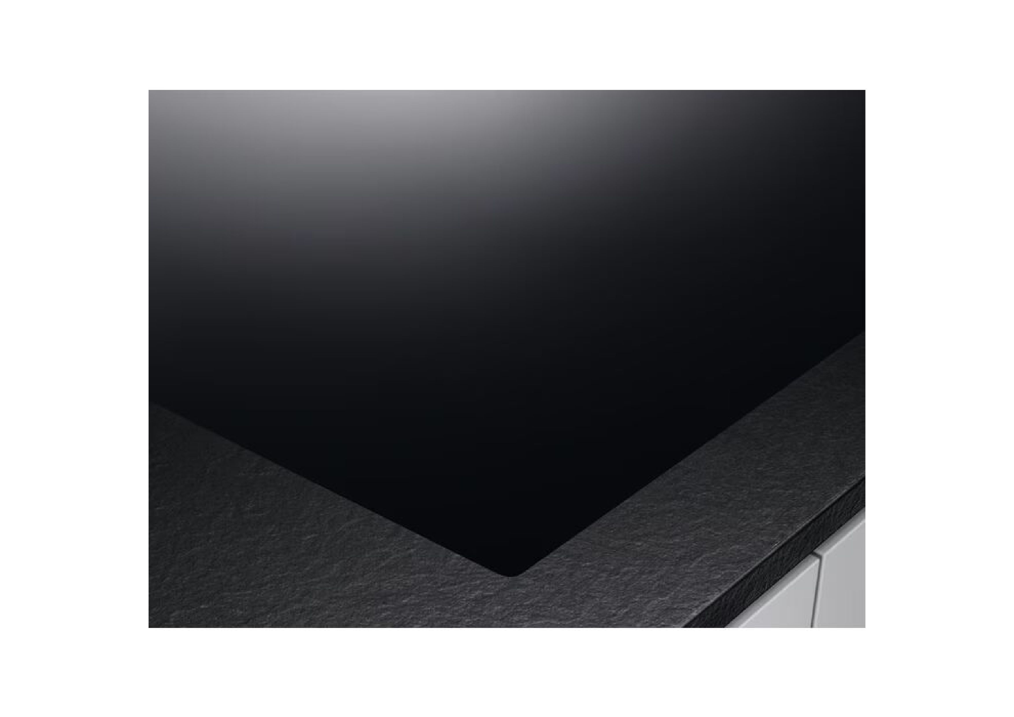 Close-up of a smooth, black glass-ceramic surface in a modern kitchen