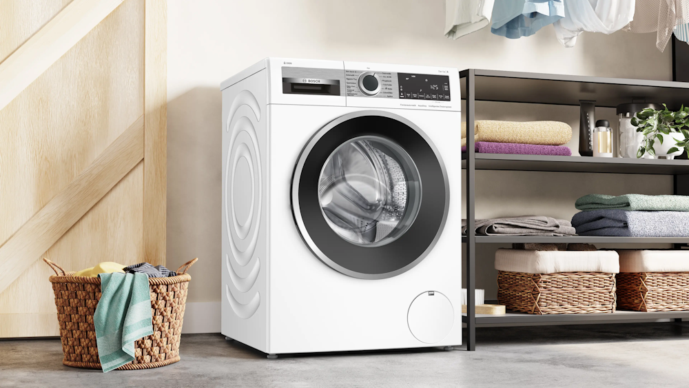 Bosch WGG244F40 Waschmaschine, Seitenansicht in hellem Hauswirtschaftsraum neben Regal mit Handtüchern