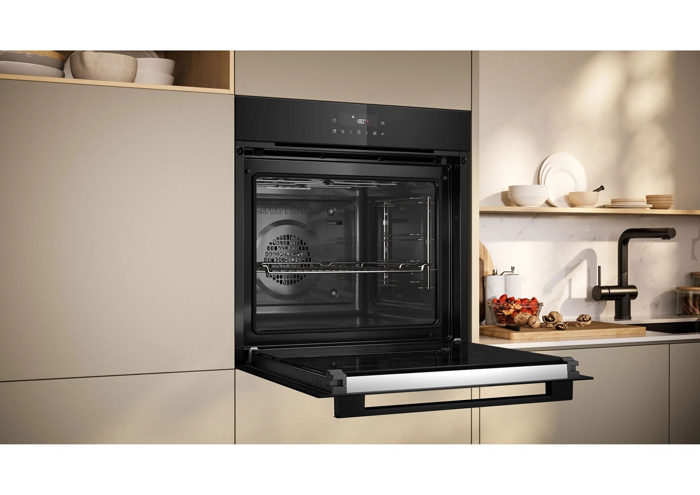 Built-in oven in a modern bright kitchen with open door and oven rack.
