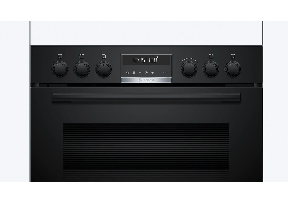 Close-up of the oven control panel showing six knobs, touch keys, and the digital clock display.