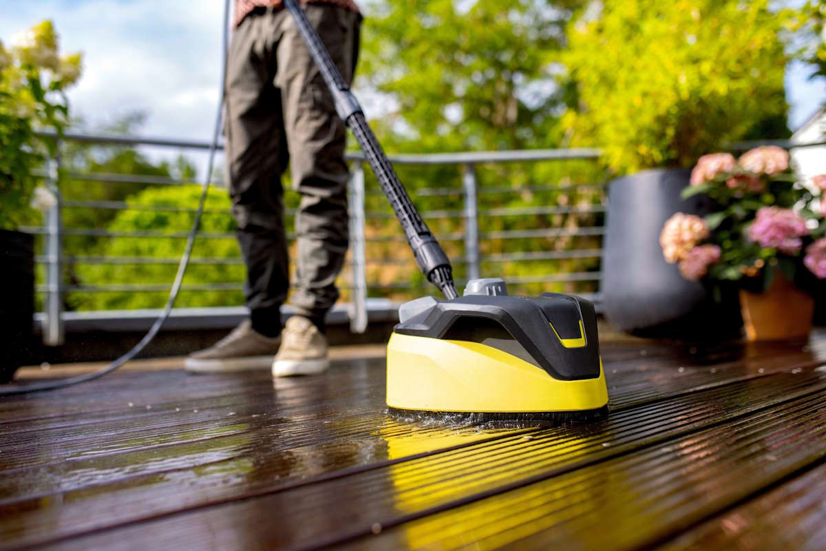 Der Kärcher T 7 Flächenreiniger wird zur spritzwasserfreien Reinigung einer verschmutzten Steinterrasse eingesetzt.