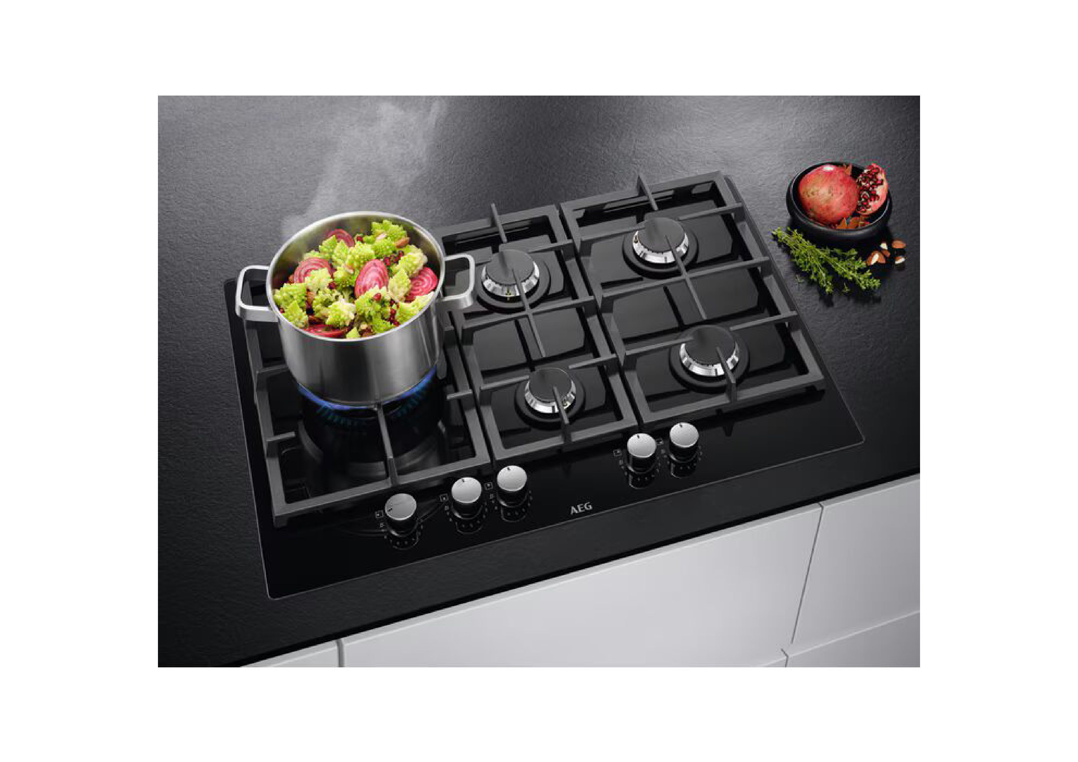 Pot with romanesco and colorful vegetables on the active wok zone of an AEG gas hob