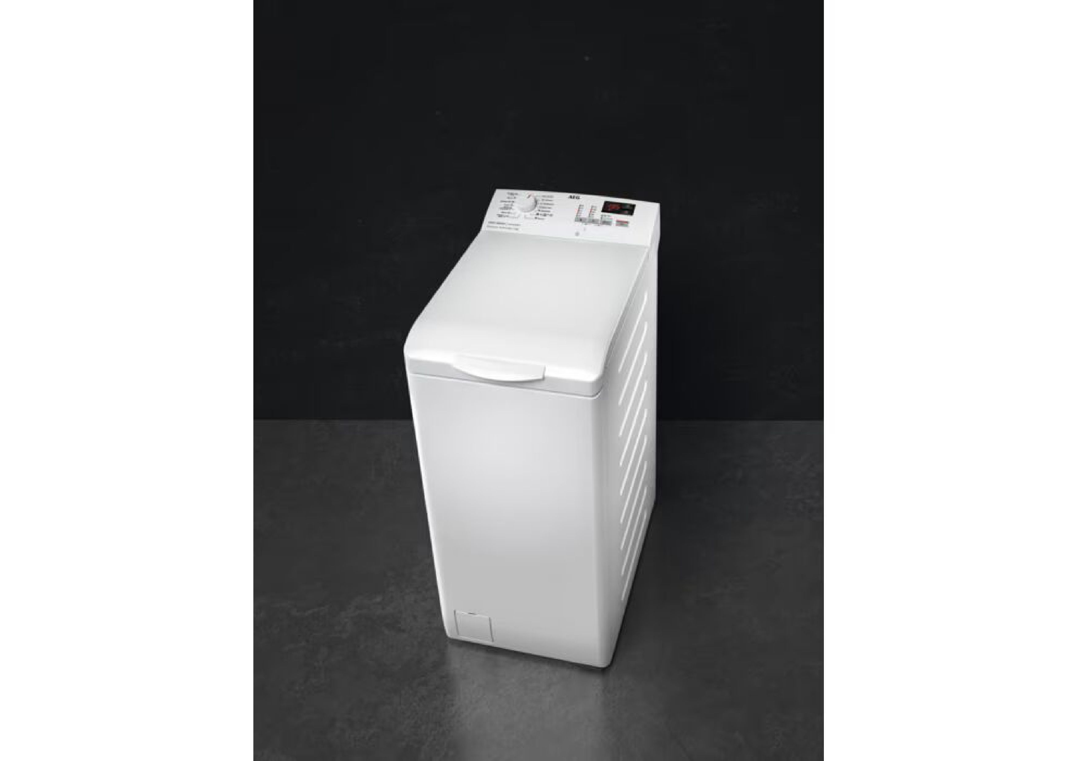 Perspective studio shot of the AEG top loader on a dark floor against a black background.