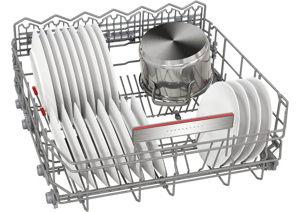 Studio shot of the lower basket (Max Flex Pro), loaded with large white dinner plates, deep soup plates, and a large stainless steel cooking pot, showcasing the flexible folding tines.