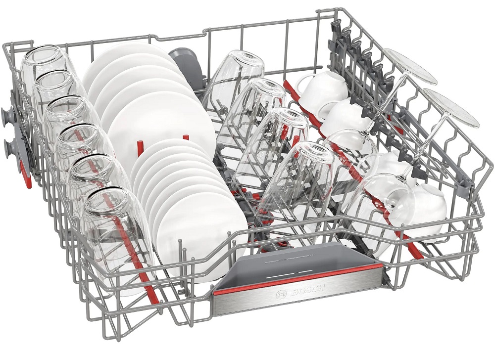 Studio view of the fully loaded upper basket (Max Flex Pro) holding various white saucers, dessert plates, drinking glasses, coffee cups, and tilted wine glasses placed on the folding racks.